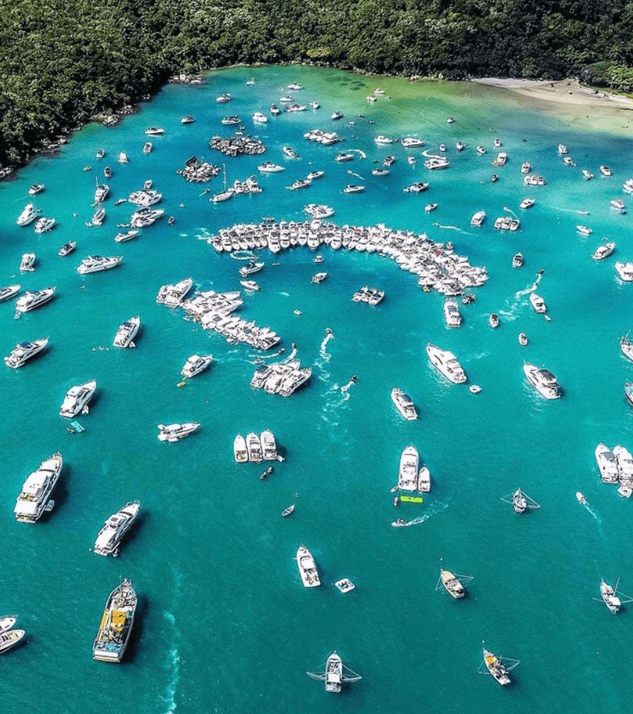 Dezenas de barcos ancorados lado a lado na enseada do Caixa D'Aço